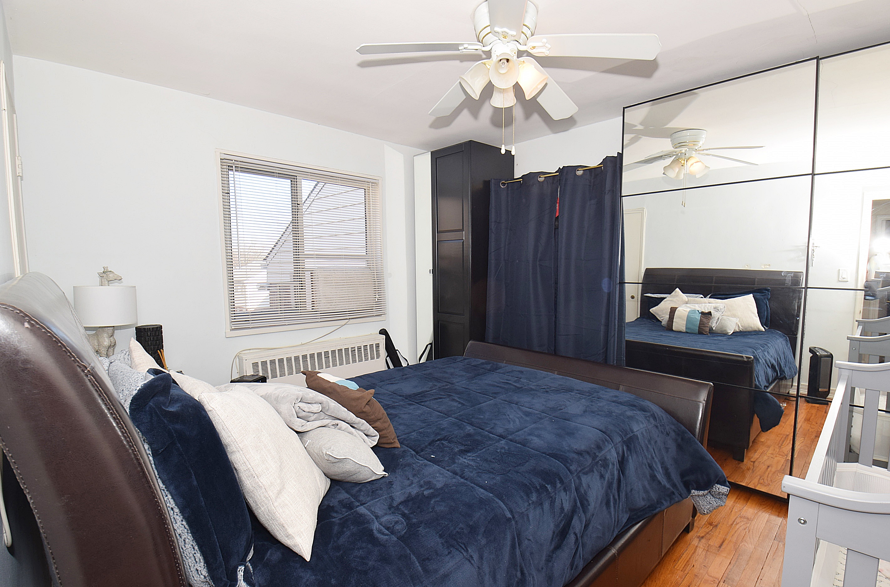 86-59 Springfield Boulevard, Unit U Queens, NY 11427 - Photo 5 of 6 a bedroom with a bed and wooden floor