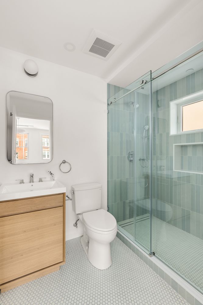 578 20th Street Brooklyn, NY 11218 - Photo 11 of 24 a bathroom with a shower sink mirror and toilet