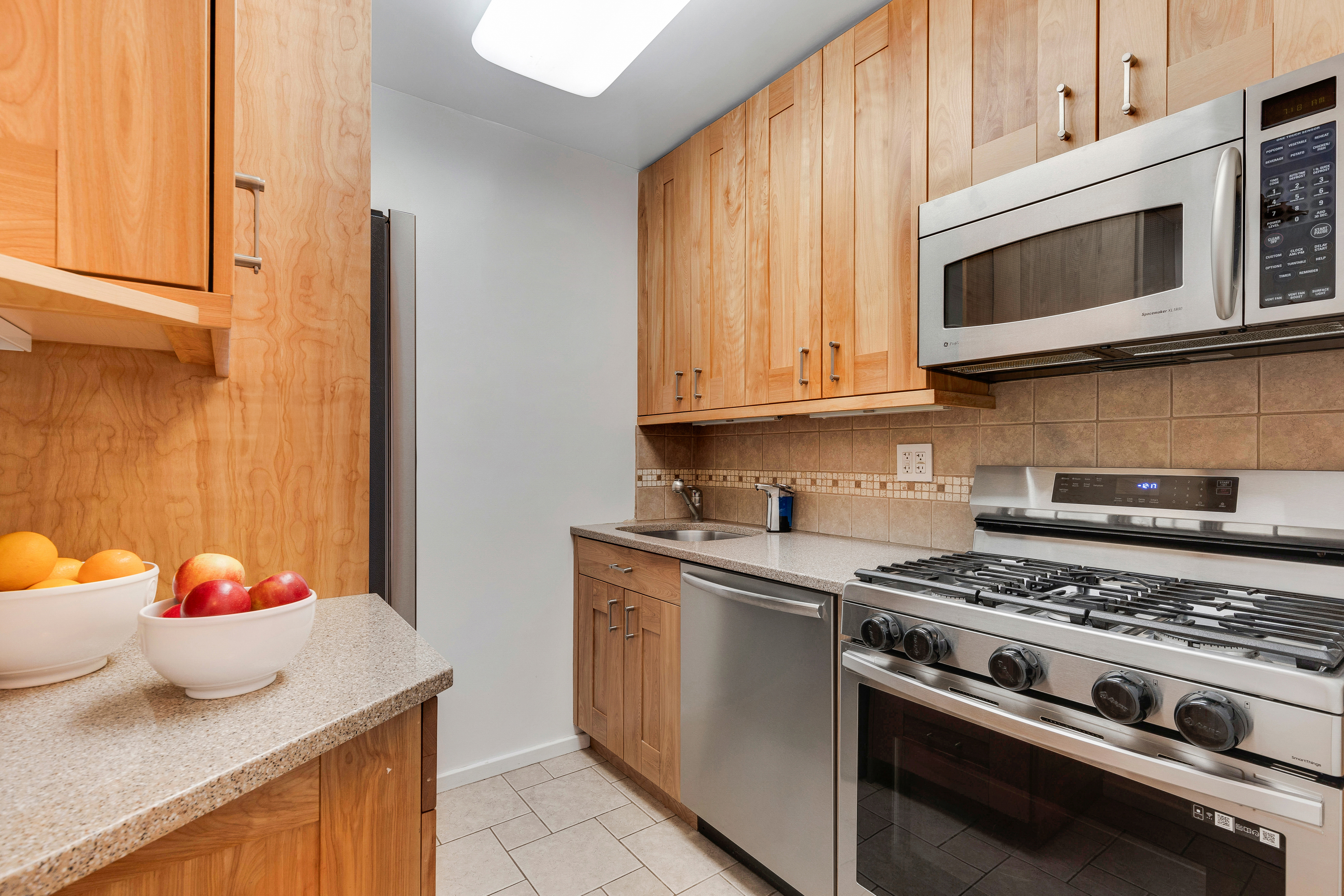 2025 Broadway, Unit 7AB Manhattan, NY 10023 - Photo 4 of 13 a kitchen with stainless steel appliances granite countertop a sink and a stove