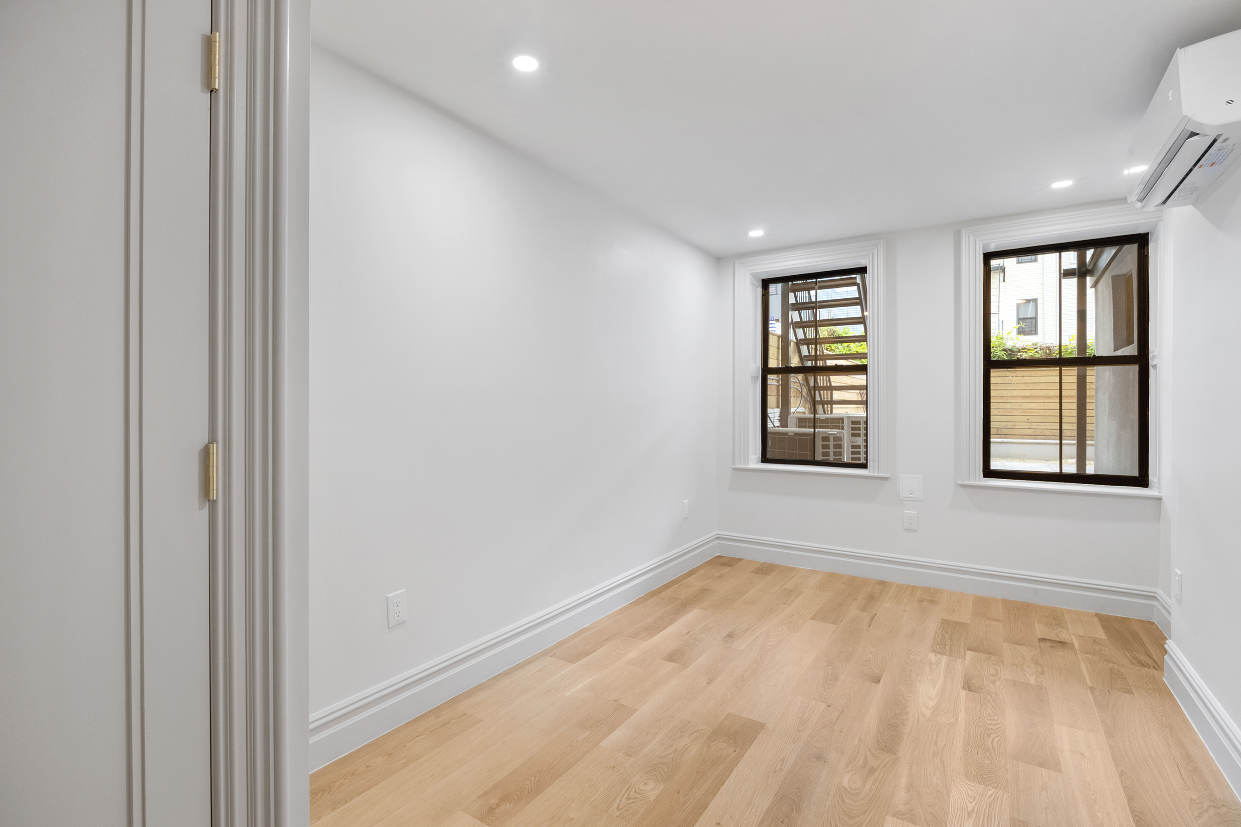 306 Halsey Street Brooklyn, NY 11216 - Photo 5 of 10 a view of empty room with wooden floor and fan