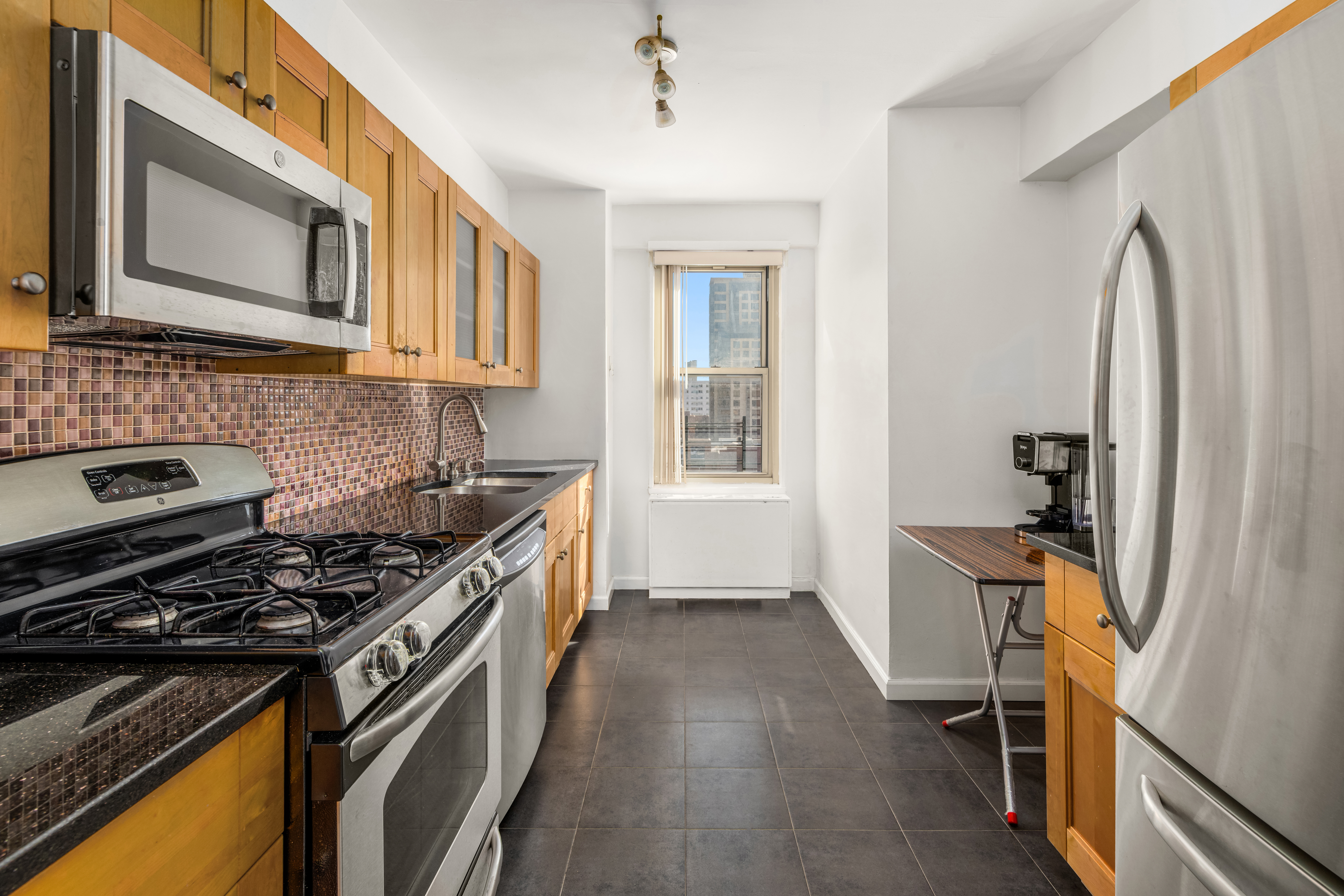 107-40 Queens Boulevard, Unit 11A Queens, NY 11375 - Photo 3 of 10 a kitchen with stainless steel appliances a stove a sink and a refrigerator