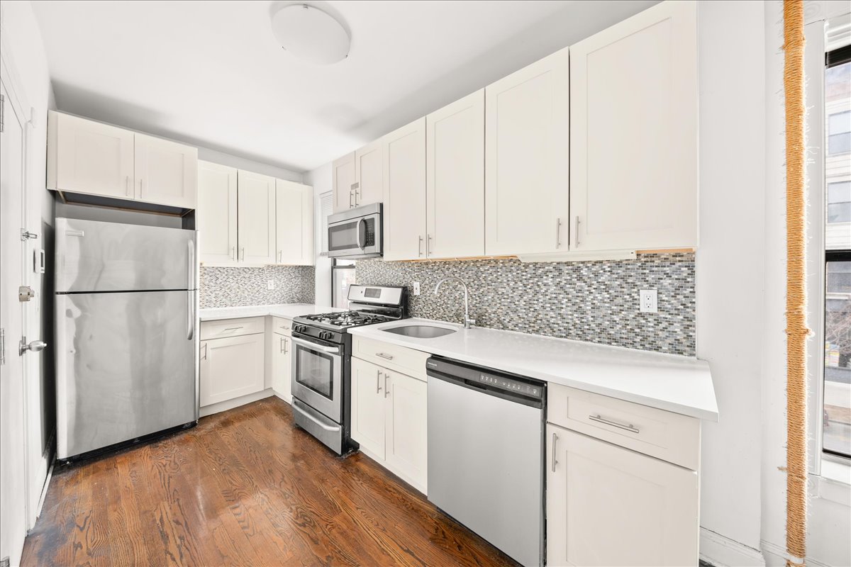 478 Halsey Street, Unit 1 Brooklyn, NY 11233 - Photo 4 of 10 a kitchen with white cabinets and white appliances