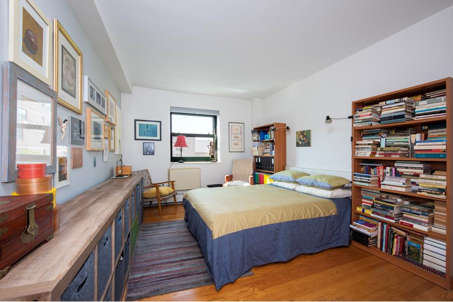 1885 Lexington Avenue, Unit 6D Manhattan, NY 10035 - Photo 5 of 7 a bed room with a bed and a book shelf