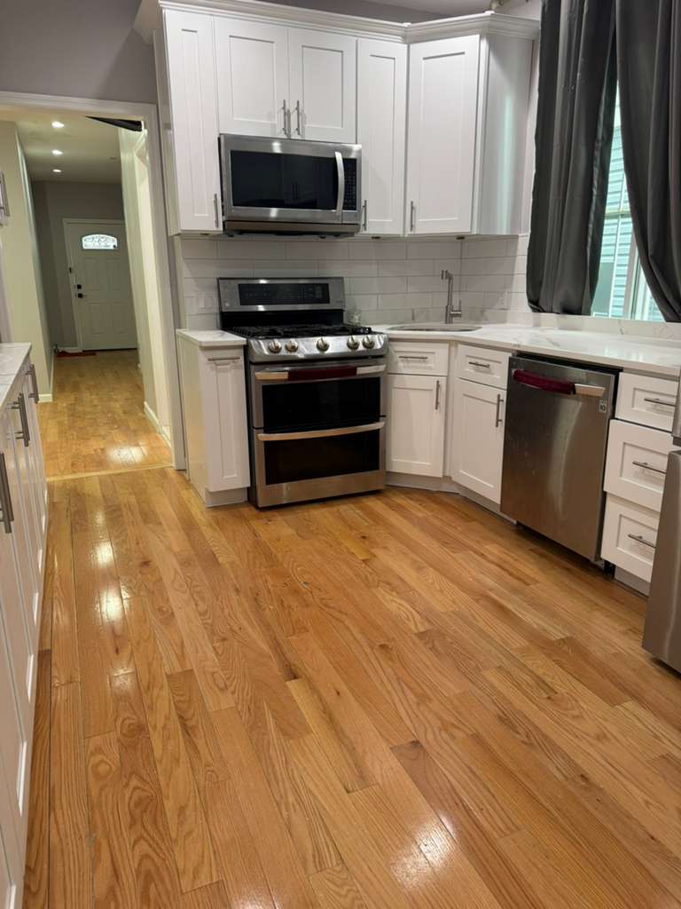 a kitchen with stainless steel appliances granite countertop a stove a sink and a microwave