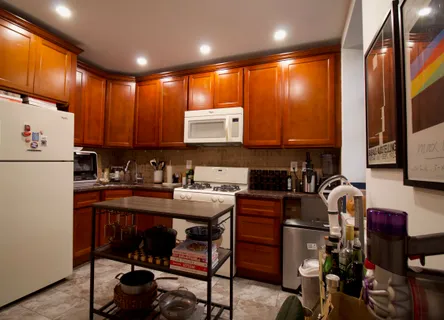 a kitchen with sink a refrigerator and chairs