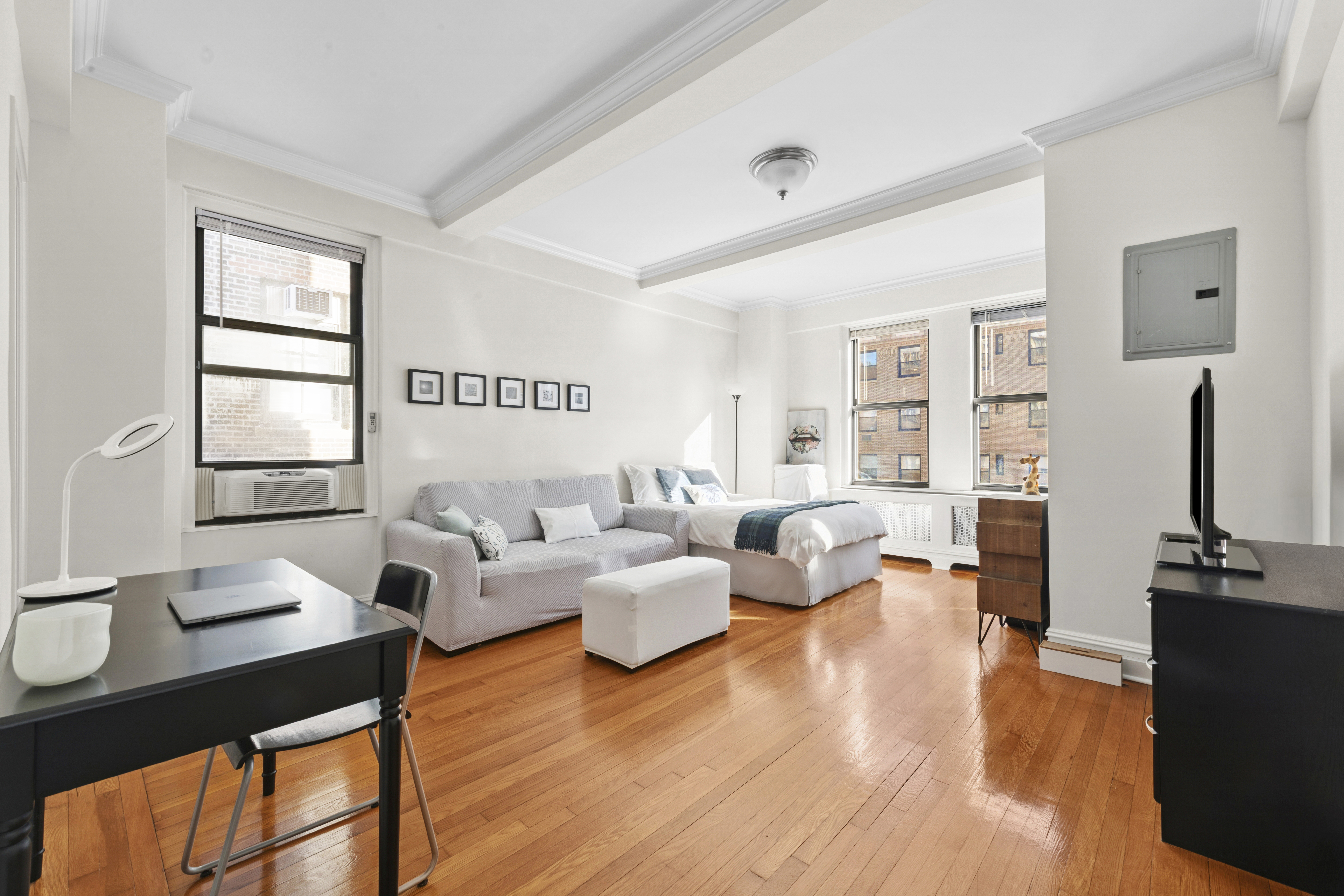 243 West End Avenue, Unit 1104 Manhattan, NY 10023 - Photo 2 of 10 a living room with furniture flat screen tv and wooden floor