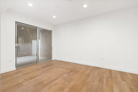 an empty room with wooden floor and door