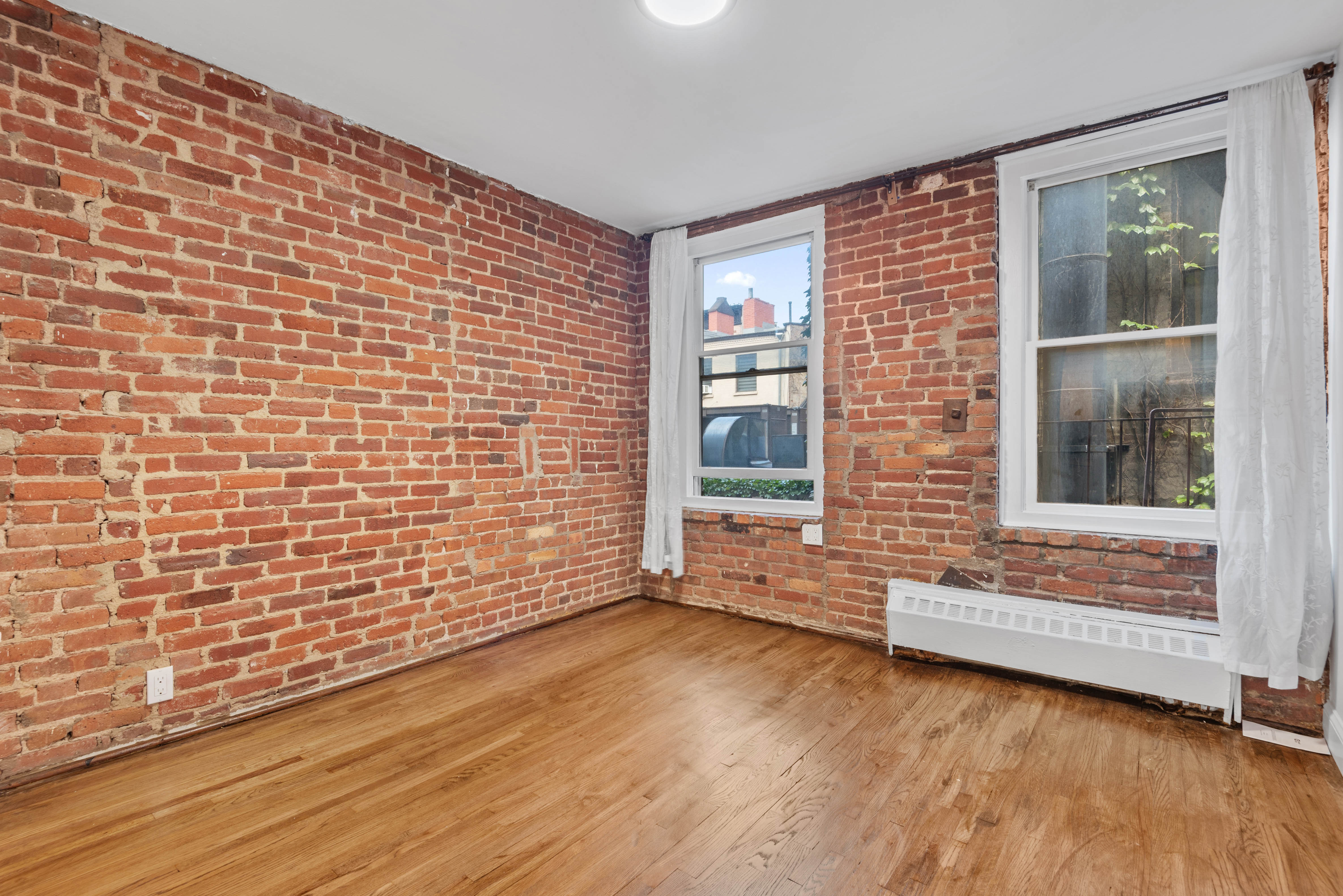 15 Jones Street, Unit 3C Manhattan, NY 10014 - Photo 3 of 5 a view of an empty room with wooden floor and a window