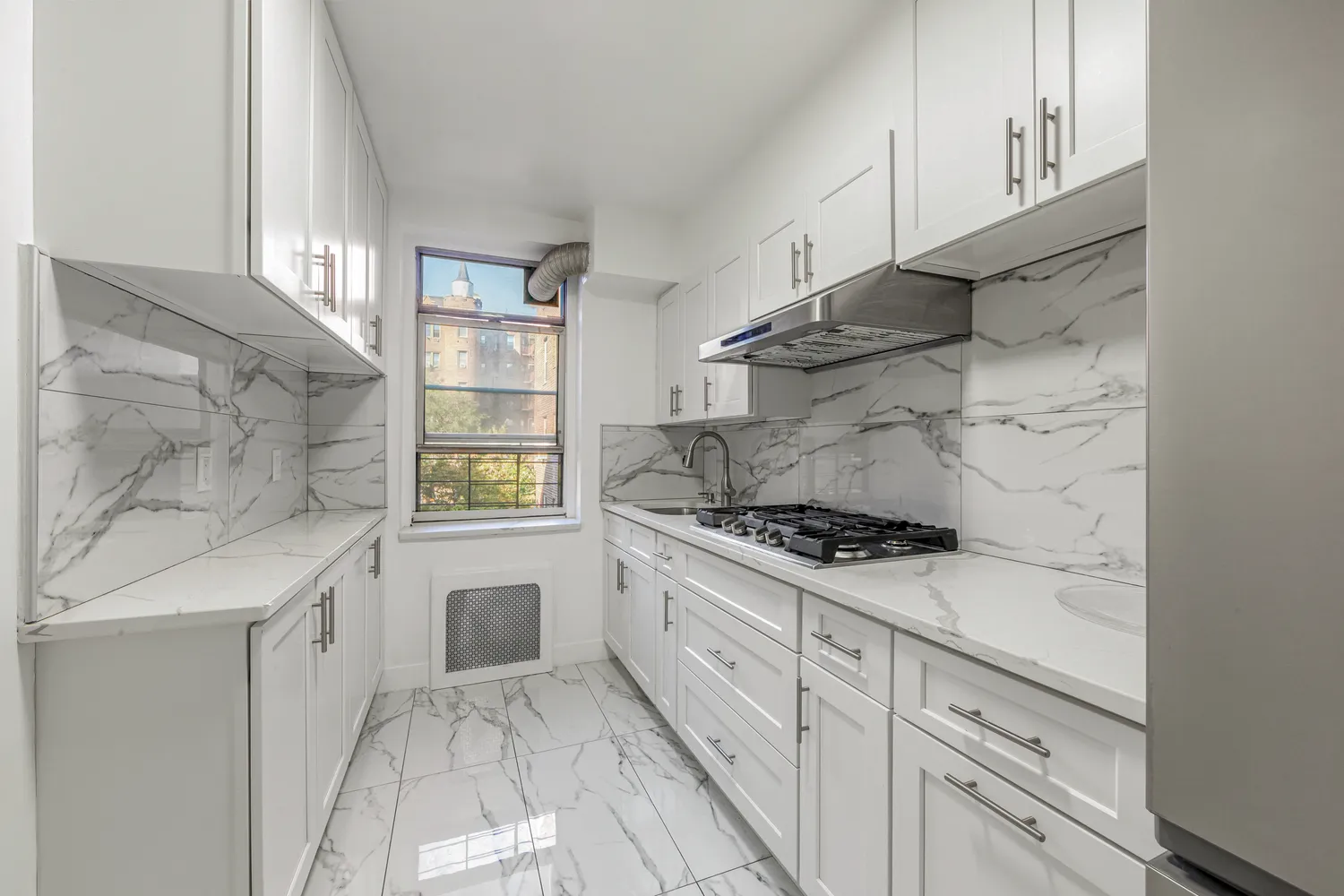 a kitchen with white cabinets and appliances