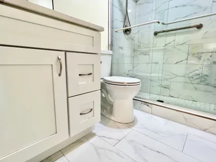 a white toilet sitting next to a bathroom