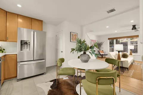 a dining room with furniture a kitchen view and a refrigerator