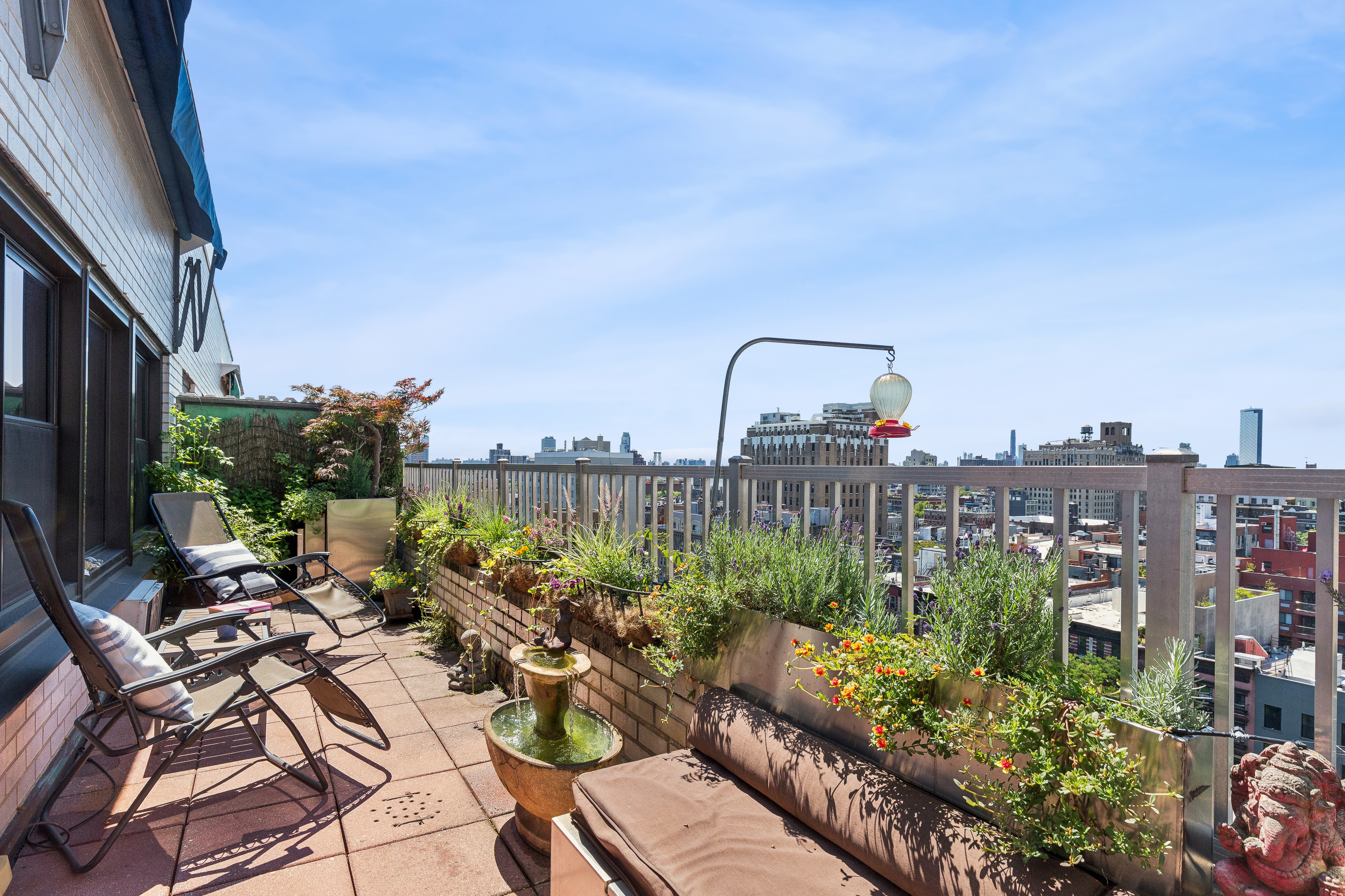 a view of a roof deck with couches and potted plants