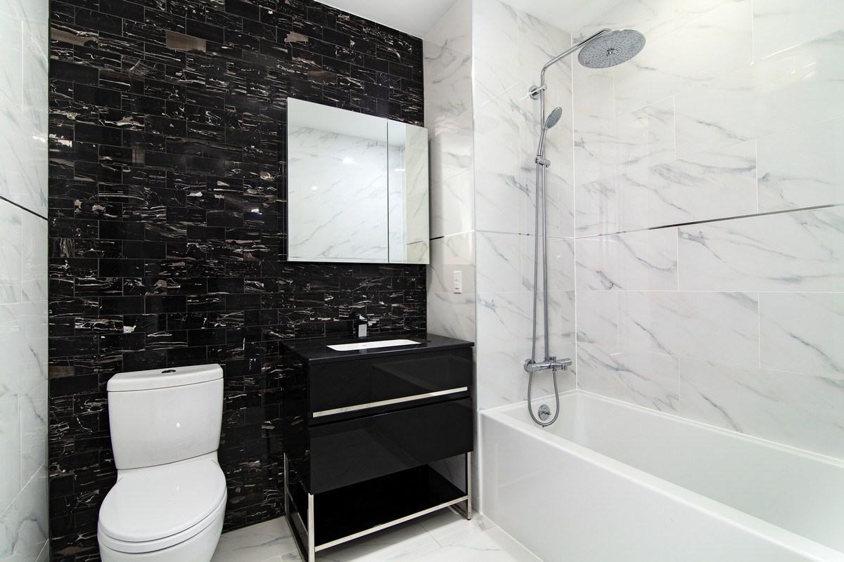 11-12 44th Drive, Unit 2B Queens, NY 11101 - Photo 14 of 15 a bathroom with a toilet a sink and bathtub