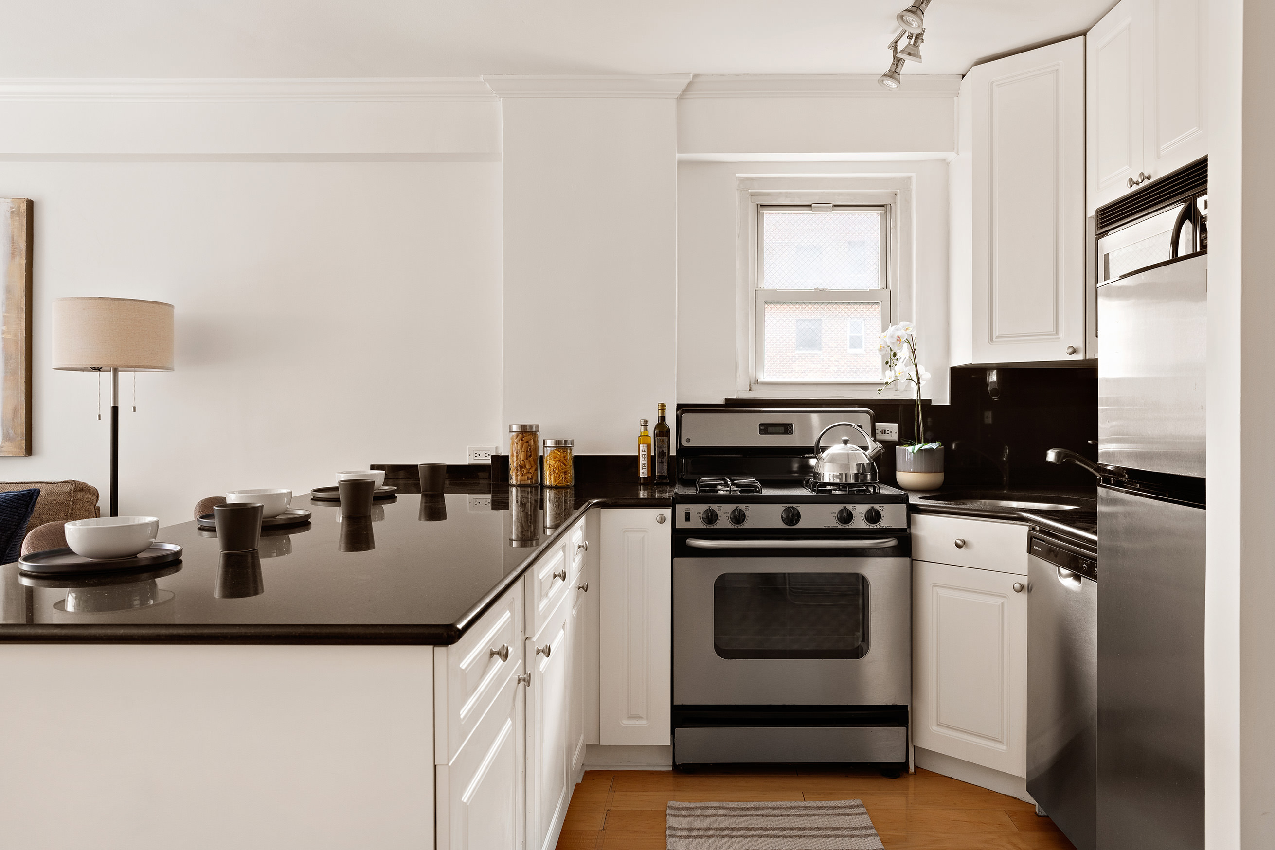 330 East 49th Street, Unit 9C Manhattan, NY 10017 - Photo 5 of 13 a kitchen with a stove a sink and a refrigerator