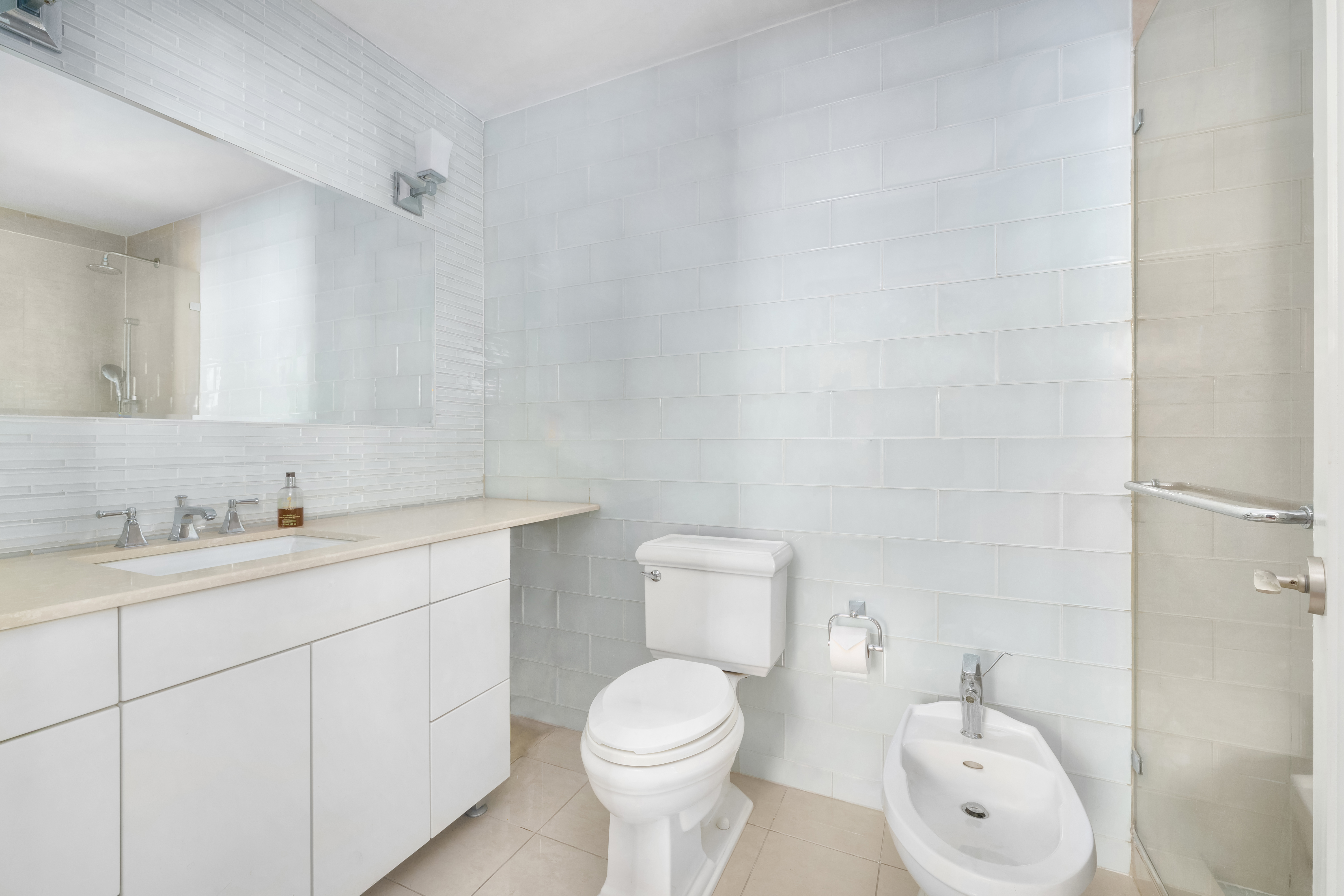 514 West End Avenue, Unit 12BC Manhattan, NY 10024 - Photo 10 of 15 a bathroom with a toilet sink vanity and mirror
