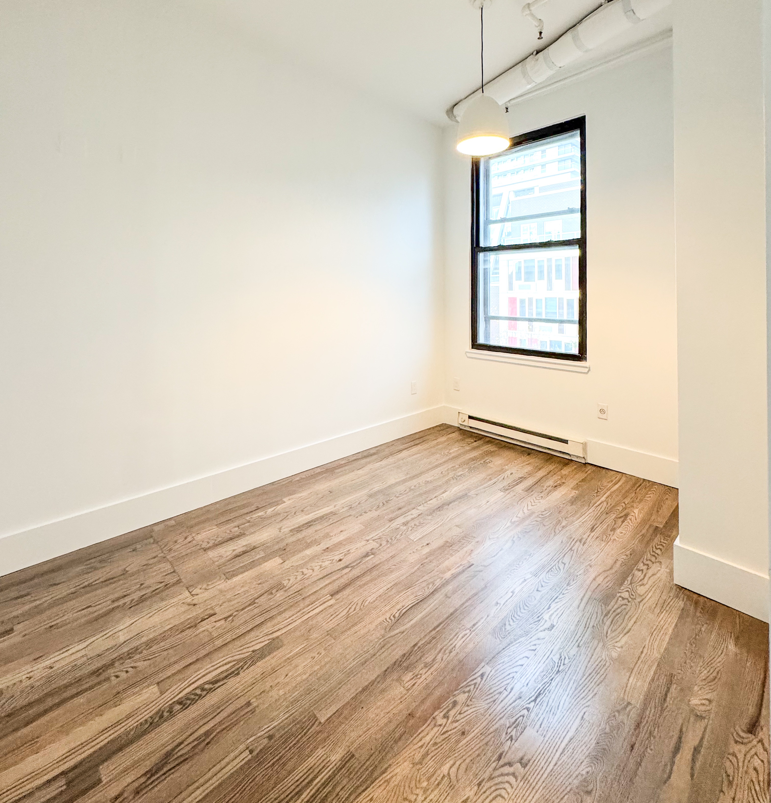 44 Berry Street, Unit 4J Brooklyn, NY 11249 - Photo 6 of 8 an empty room with wooden floor and windows