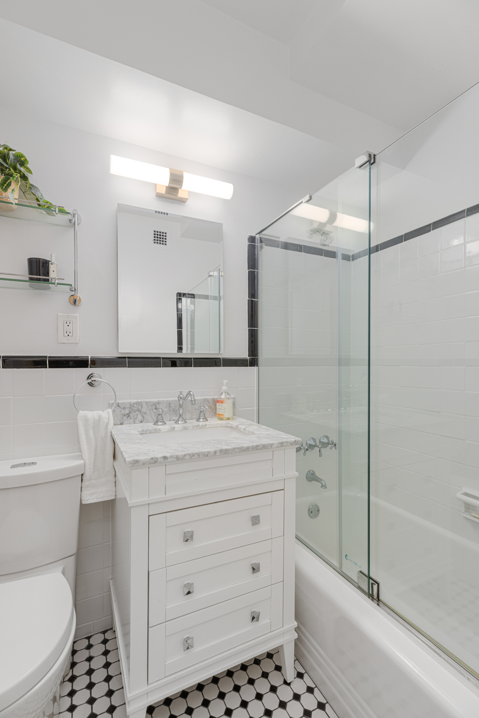 345 West 58th Street, Unit 4Y Manhattan, NY 10019 - Photo 9 of 12 a bathroom with a sink a toilet and shower