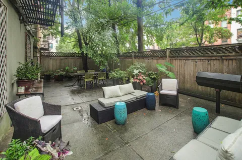 a view of a patio with couches table and chairs and potted plants