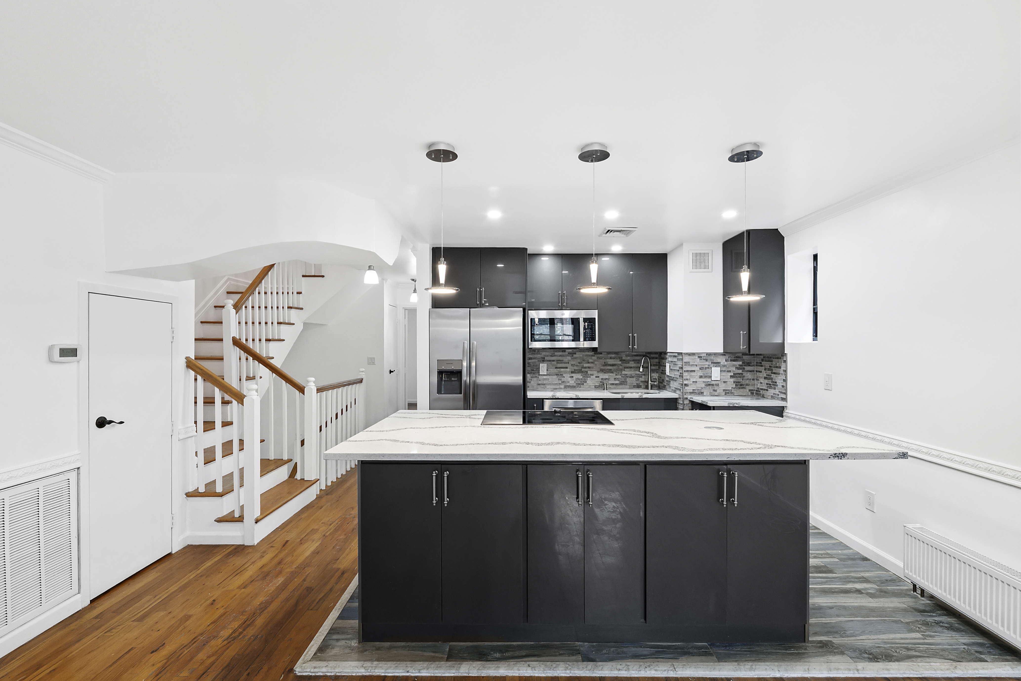 112 Pulaski Street, Unit TRIPLEX Brooklyn, NY 11206 - Photo 2 of 13 a living room with kitchen island furniture a sink and wooden floor