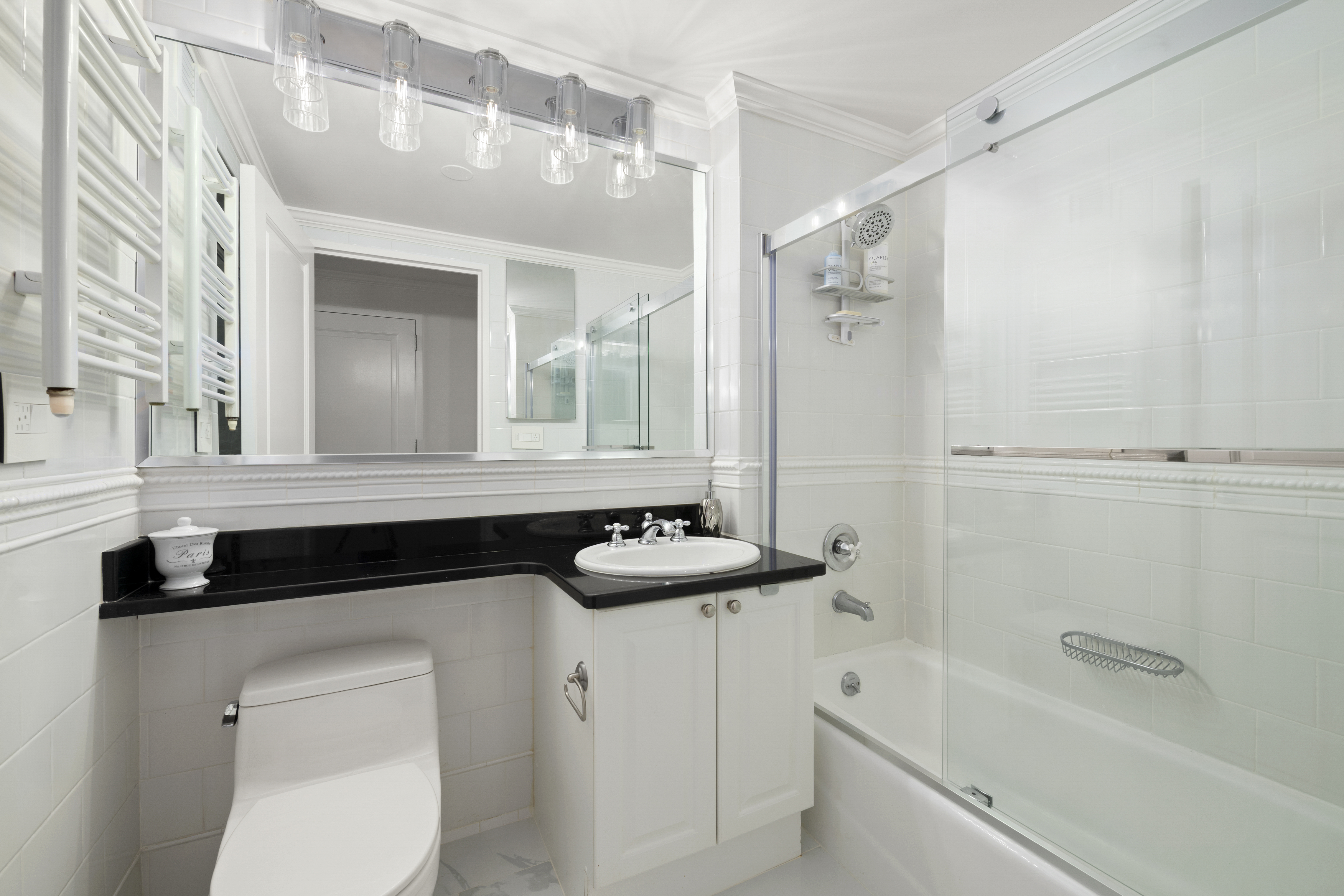 404 East 76th Street, Unit 17A Manhattan, NY 10021 - Photo 7 of 18 a bathroom with a granite countertop sink a toilet a mirror and bathtub