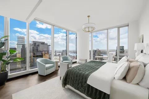 a bedroom with furniture and large windows