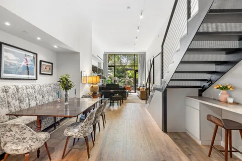 a dining room with furniture entryway and wooden floor