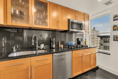 a kitchen with stainless steel appliances granite countertop a lot of cabinets a stove and a refrigerator