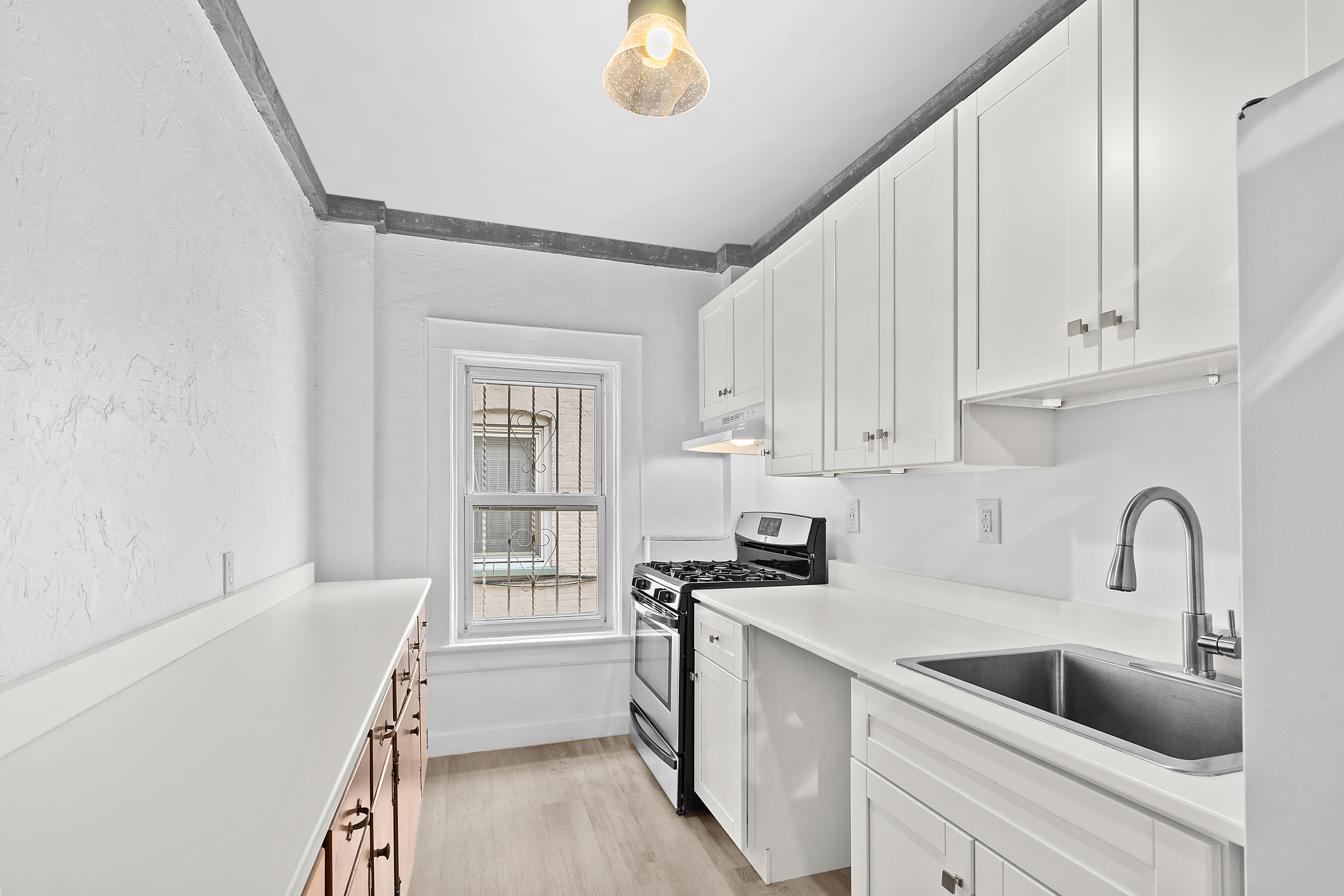 825 East 21st Street Brooklyn, NY 11210 - Photo 13 of 22 a kitchen with white cabinets and sink