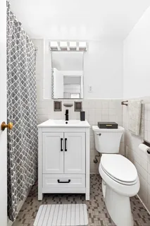 a bathroom with a sink a toilet and mirror