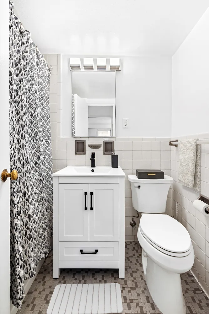a bathroom with a sink a toilet and mirror