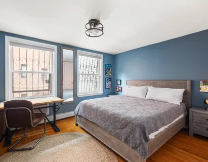 a bedroom with a bed a couch and a window