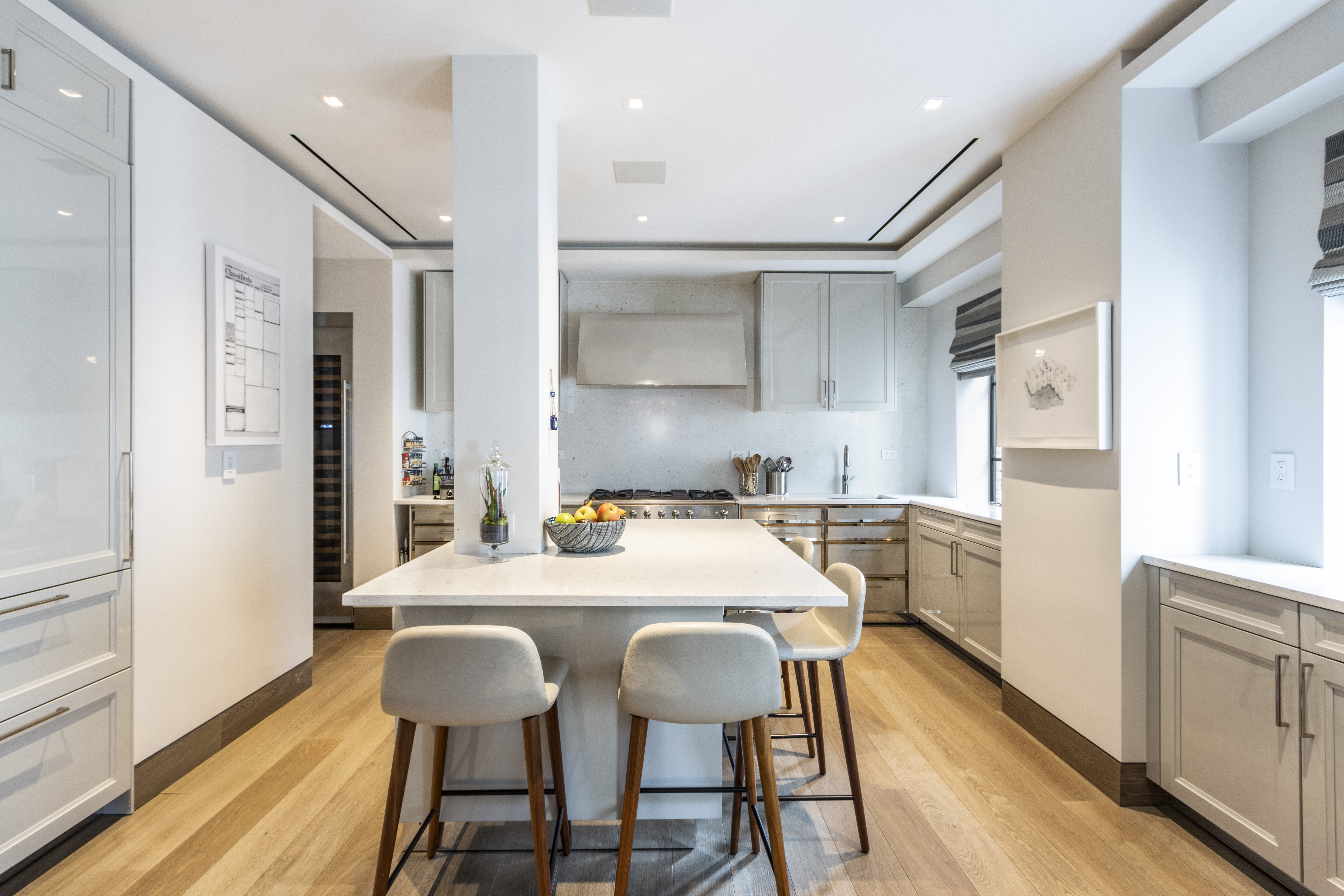 40 East 61st Street, Unit 18A Manhattan, NY 10065 - Photo 5 of 15 a kitchen with stainless steel appliances a dining table chairs and wooden floor