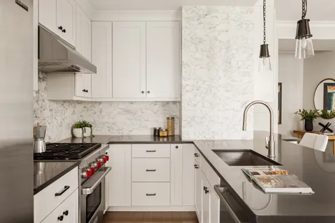 a kitchen with sink a stove and cabinets