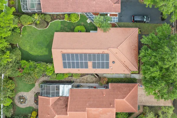 a front view of a house with a yard and potted plants