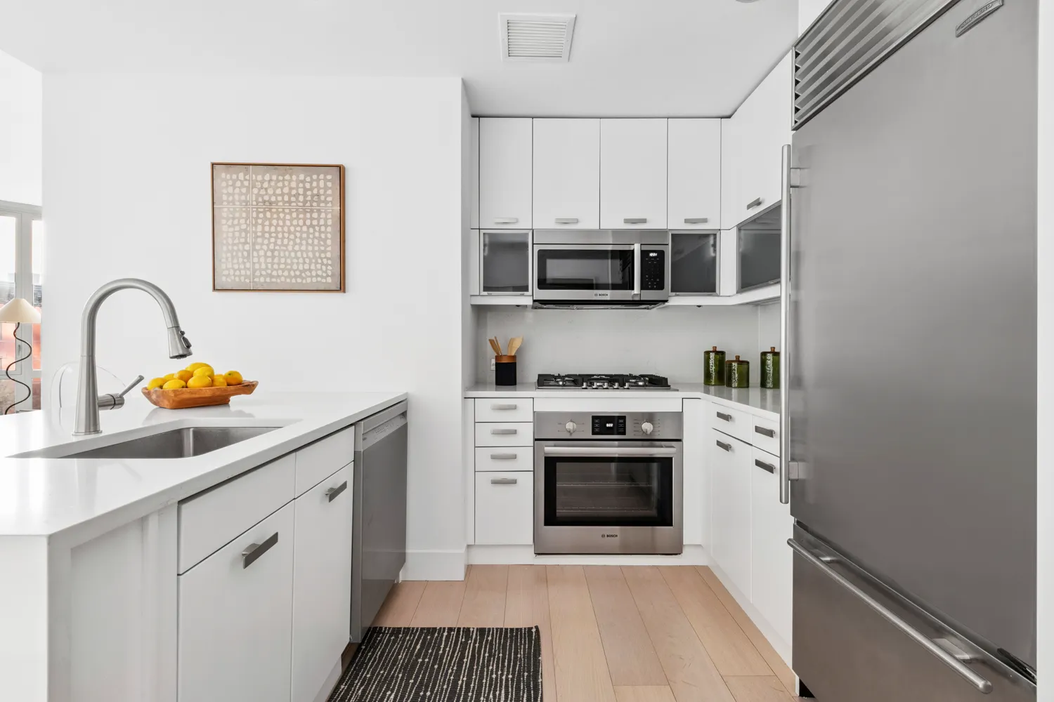 a kitchen with stainless steel appliances granite countertop a stove a microwave and a sink