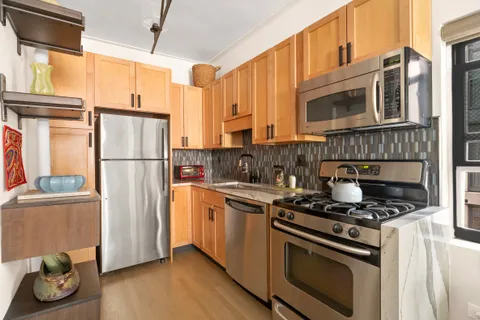 a kitchen with stainless steel appliances granite countertop a refrigerator sink and stove