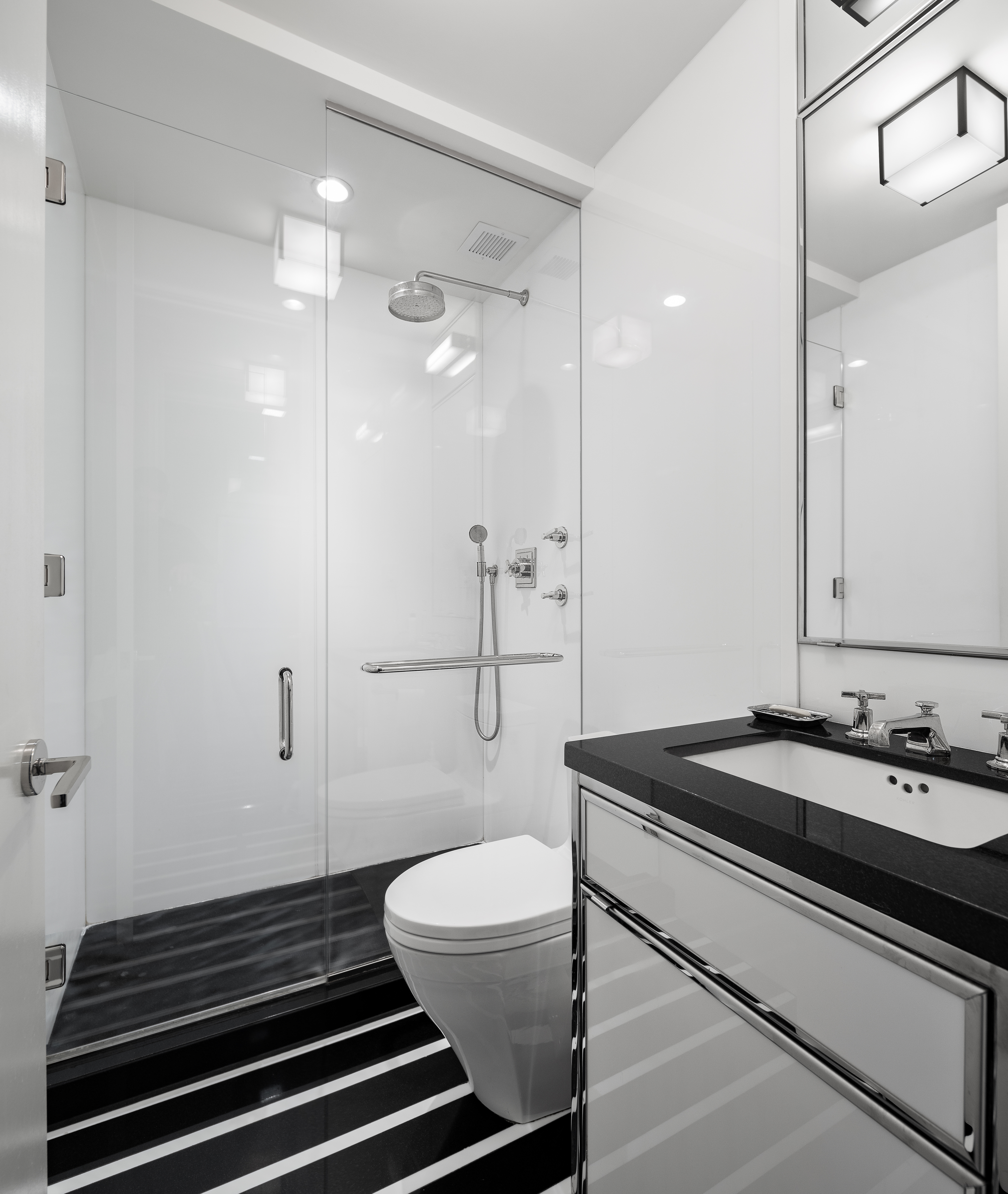 1001 5th Avenue, Unit 4C Manhattan, NY 10028 - Photo 8 of 11 a bathroom with a sink a toilet a mirror and shower