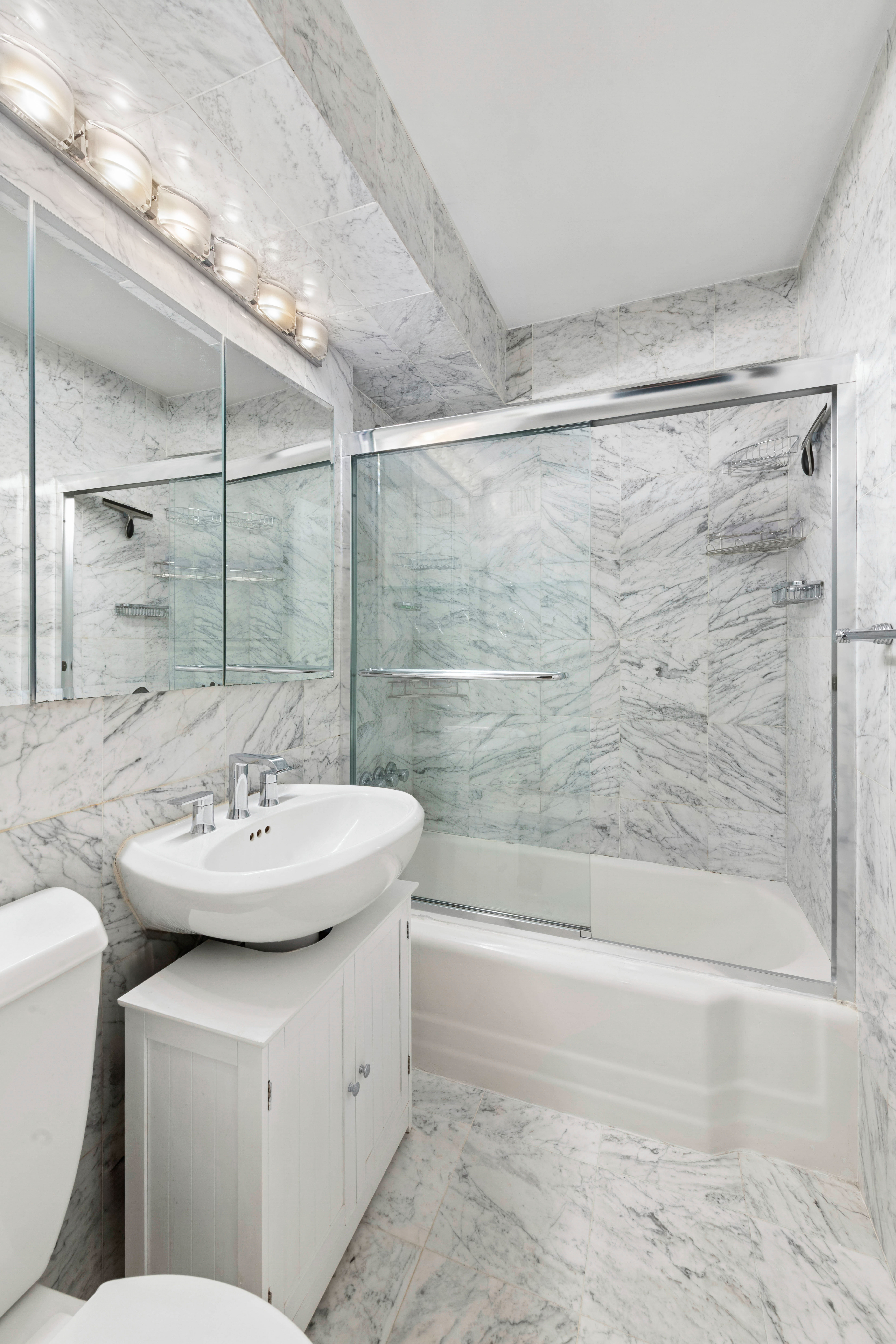 205 East 77th Street, Unit 4B Manhattan, NY 10075 - Photo 6 of 10 a bathroom with a sink mirror toilet and bathtub