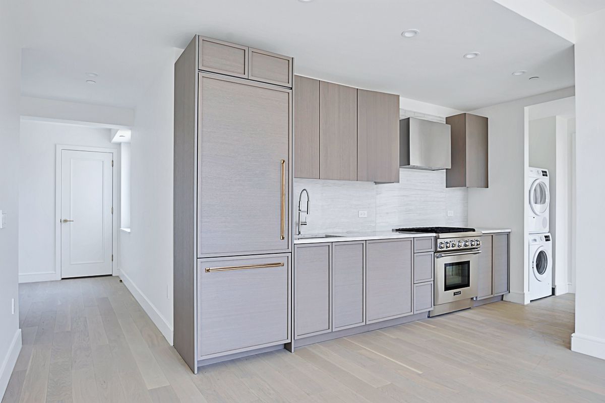 1399 Park Avenue, Unit 7B Manhattan, NY 10029 - Photo 2 of 14 a kitchen with white cabinets and stainless steel appliances