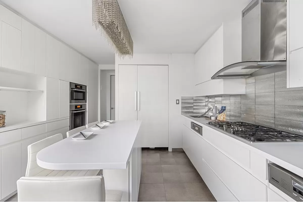 401 East 74th Street, Unit 20F Manhattan, NY 10021 - Photo 8 of 22 a kitchen with stainless steel appliances a sink and a stove