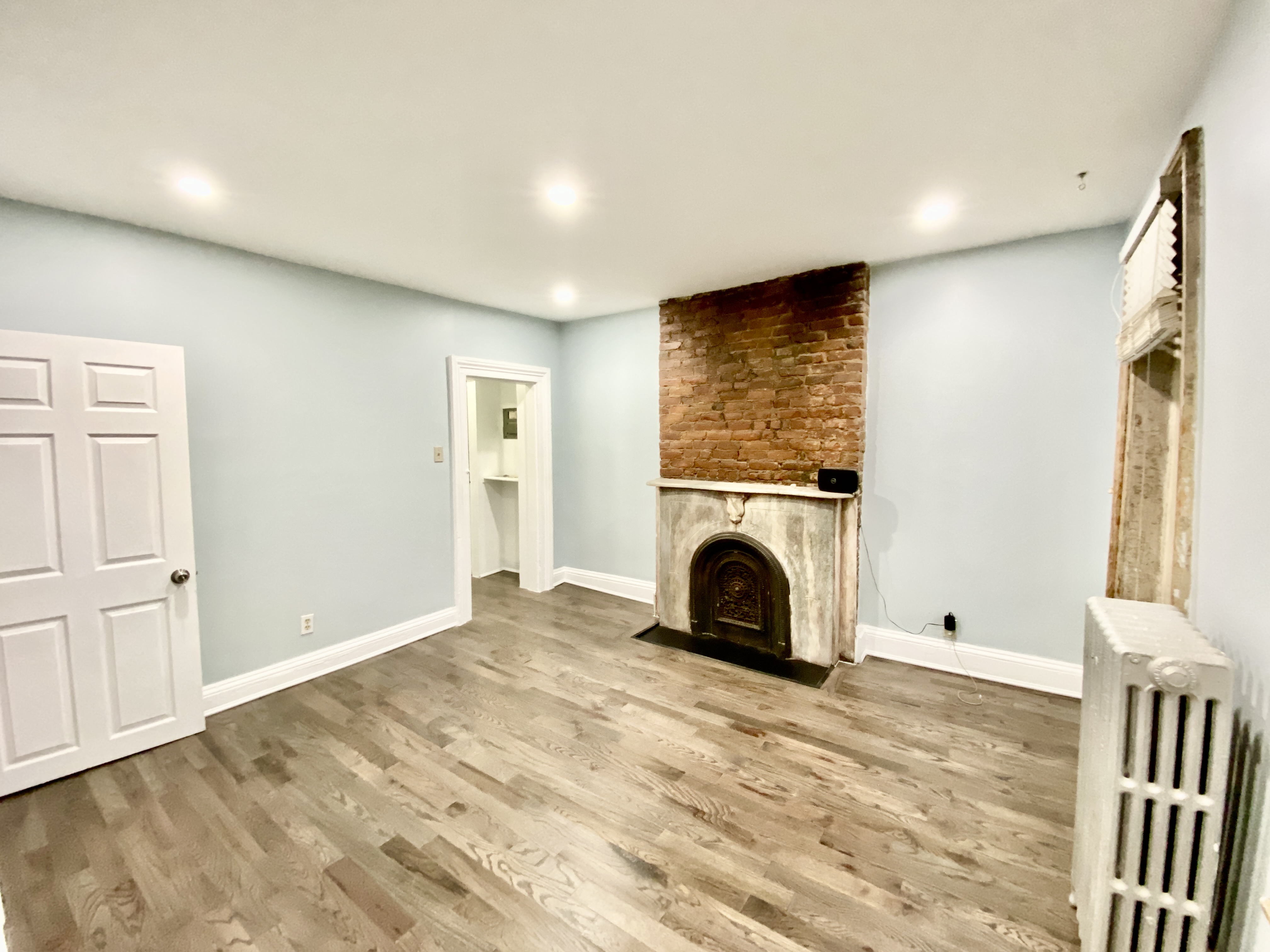 398 Decatur Street, Unit 3 Brooklyn, NY 11233 - Photo 2 of 9 a view of an empty room with window and fireplace