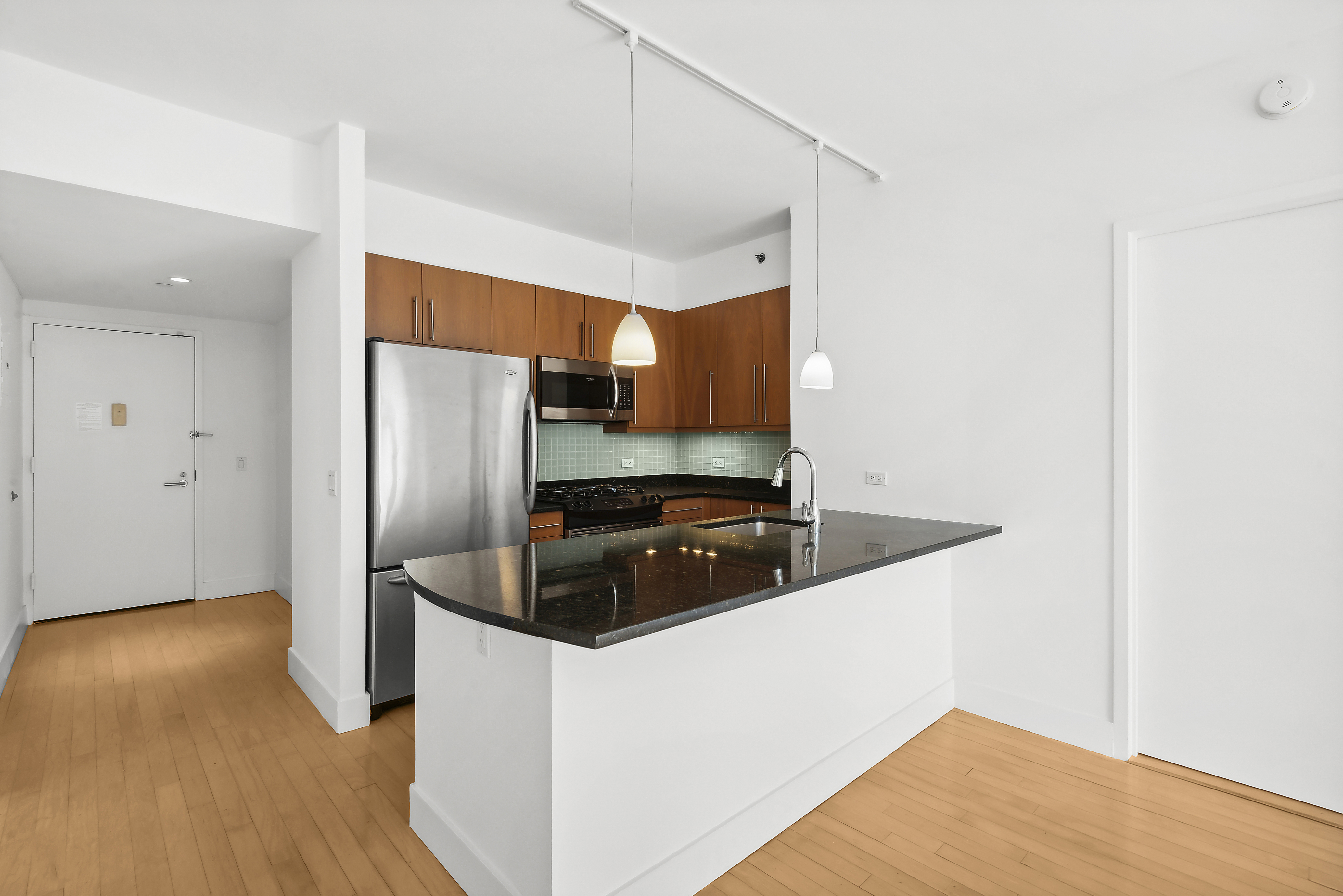 242 East 25th Street, Unit 9A Manhattan, NY 10010 - Photo 14 of 18 a kitchen with stainless steel appliances a refrigerator and a counter space