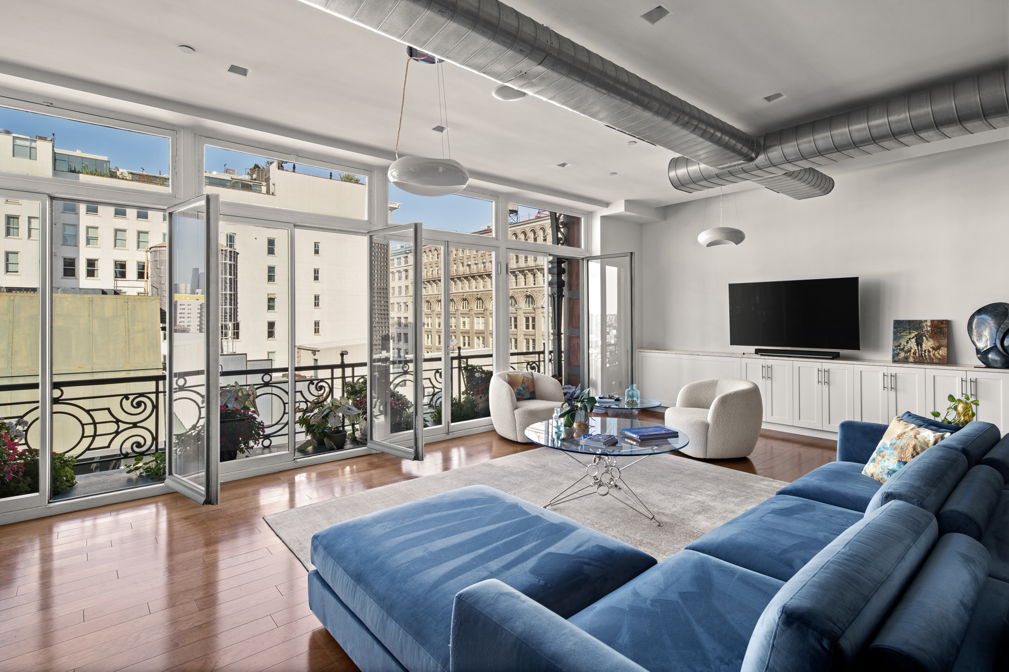 561 Broadway, Unit 10C Manhattan, NY 10012 - Photo 2 of 11 a living room with furniture and a flat screen tv