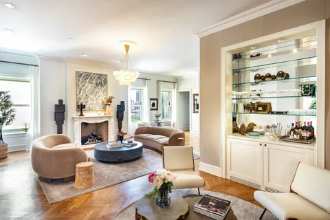 a living room with furniture a fireplace and a large mirror