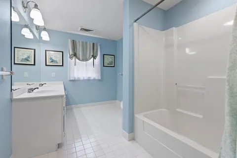 a bathroom with a tub sink and mirror