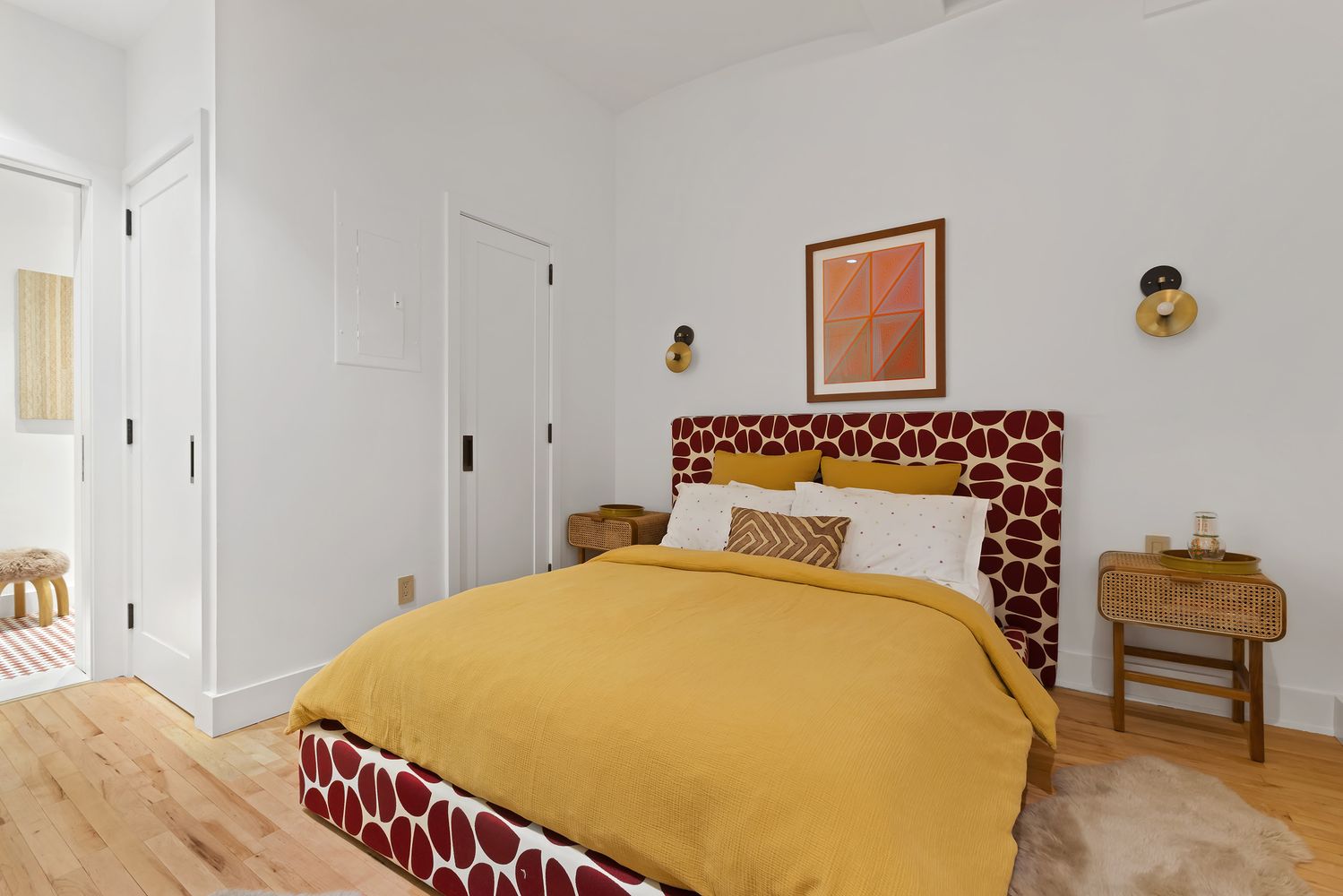 a bedroom with a bed and a lamp on dresser