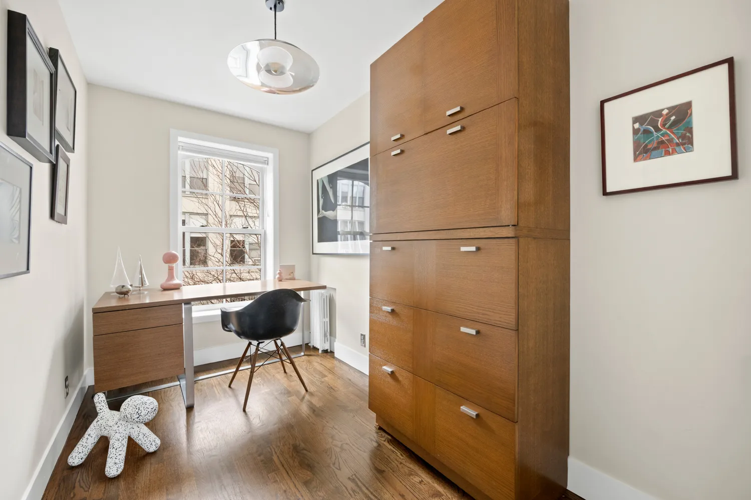 a view of a workspace with furniture and a window