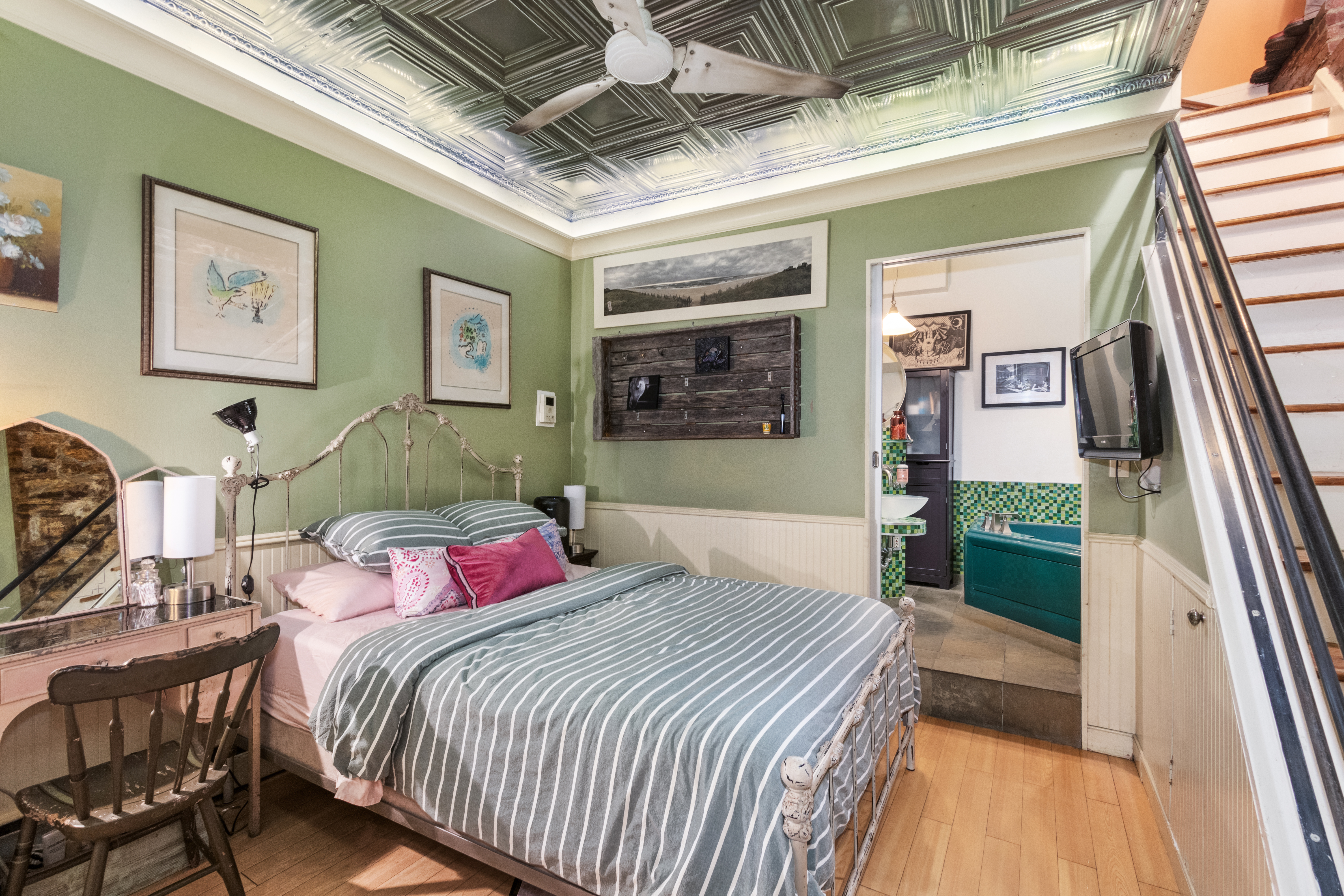 324 Pearl Street, Unit 1F Manhattan, NY 10038 - Photo 7 of 12 a bedroom with a bed a mirror and paintings on the wall