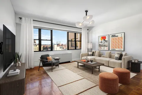 a living room with furniture a flat screen tv and a window