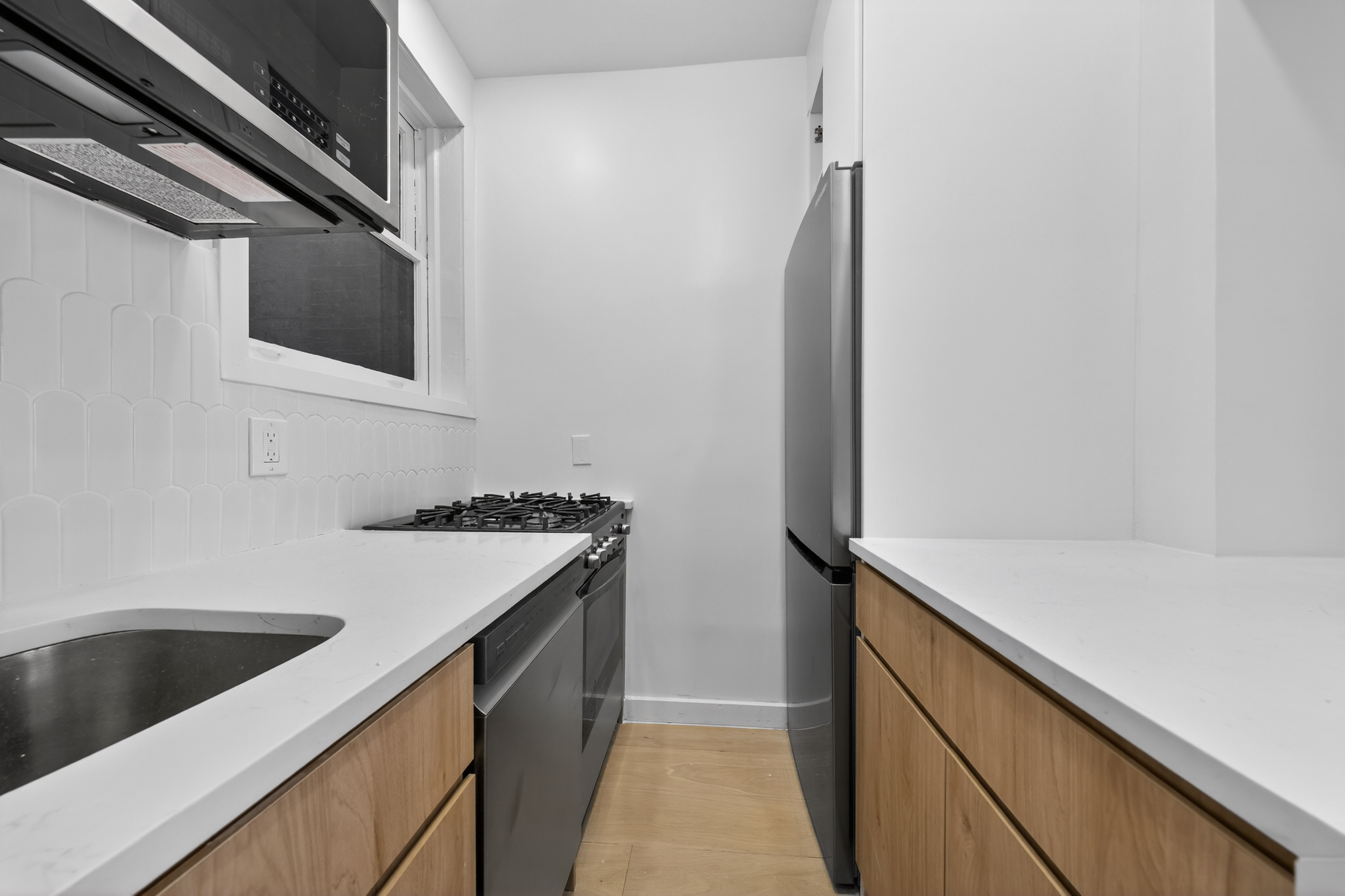 120 East 83rd Street, Unit 3D Manhattan, NY 10028 - Photo 4 of 8 a kitchen with a sink and a refrigerator